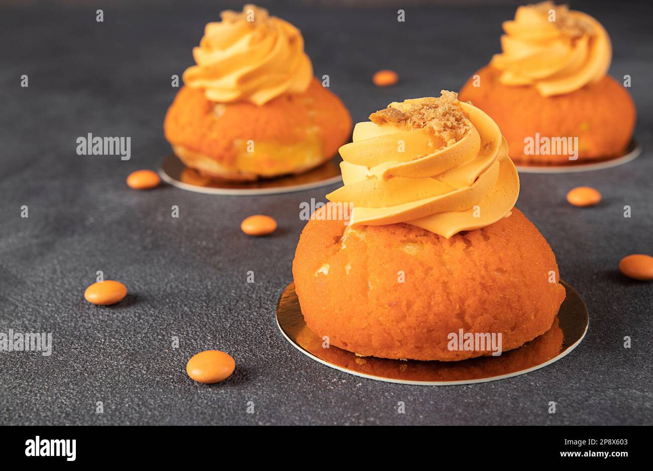 French cakes Chou of thin crispy choux pastry with a sweet shortcrust crust, mango and custard on gray background Stock Photo