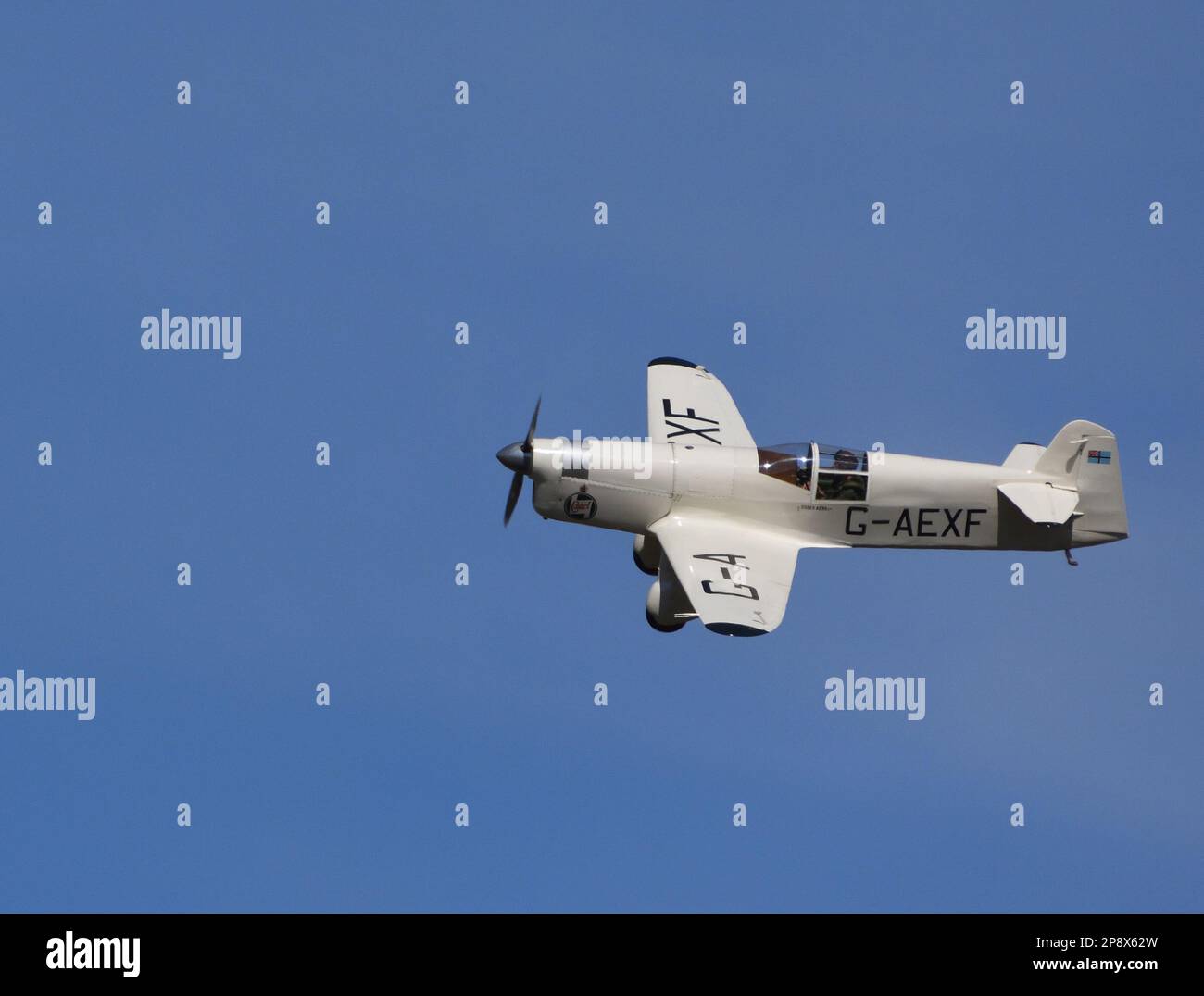 ICKWELL, BEDFORDSHIRE, ENGLAND - AUGUST 07, 2022: 1936 Percival Mew Gull  G-AEXF  Aircraft in flight with blue sky and clouds. Stock Photo