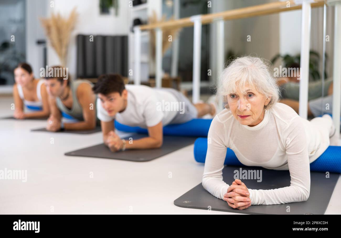 Group of different people doing exercises with roller Stock Photo