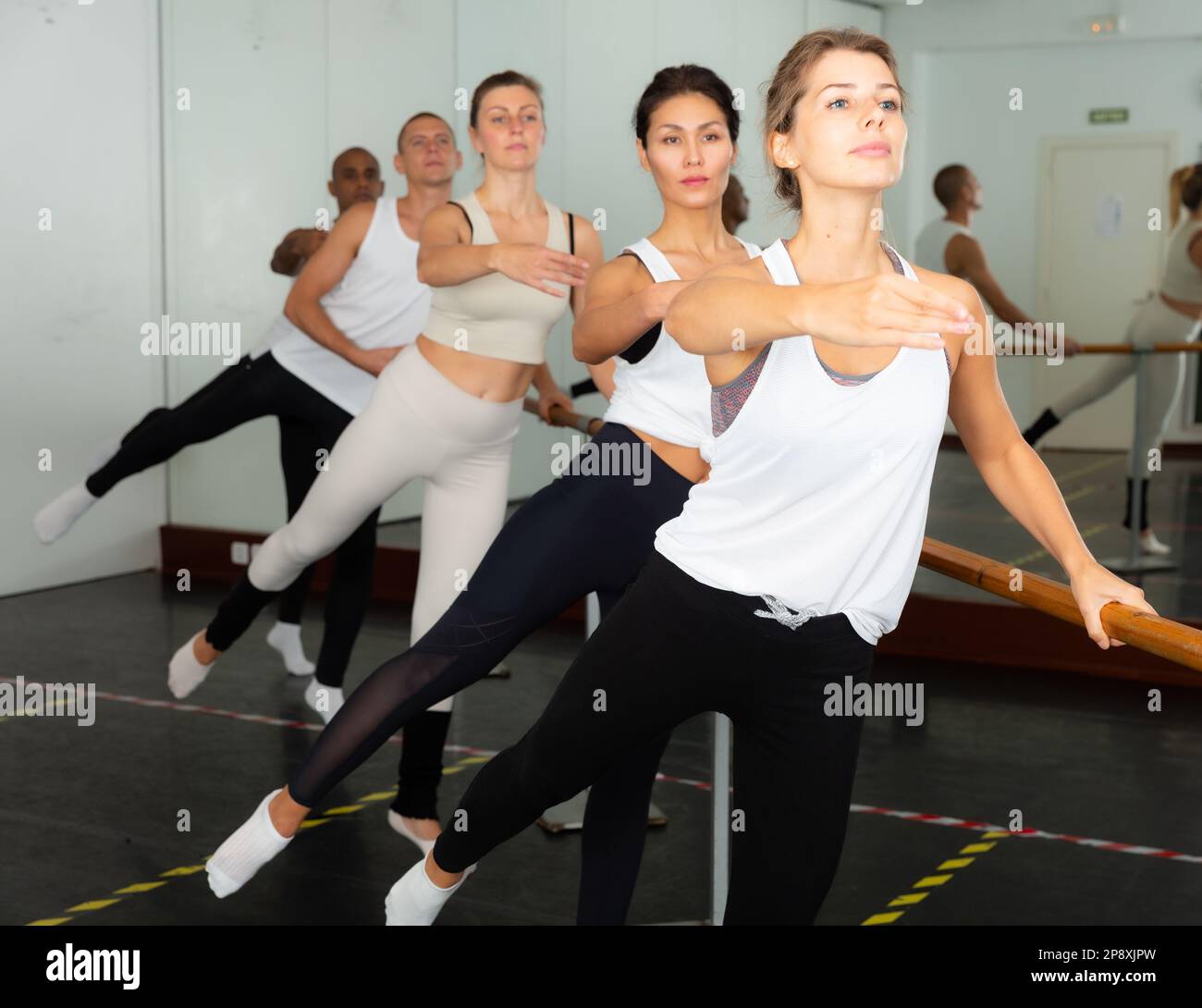 Ballet dancers practicing at barre in dance class Stock Photo