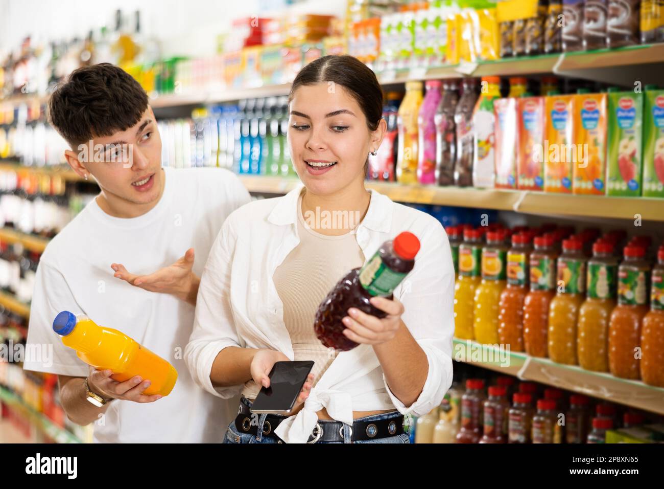 Young couple of customers scanning qrcode on soft drinks Stock Photo