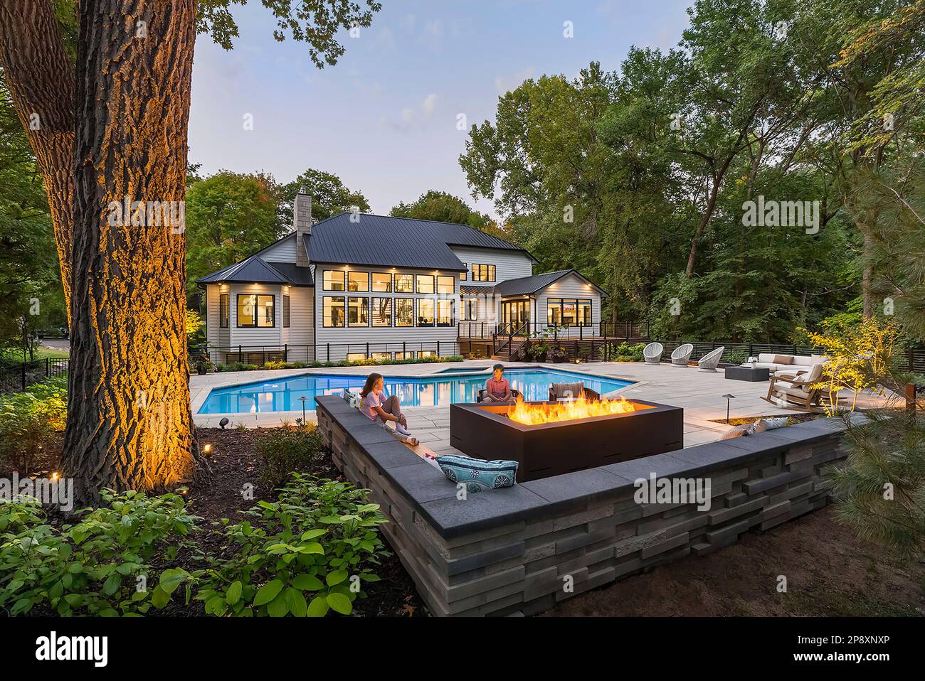 The exterior of a remodeled home with new landscaping, plantings and a swimming pool Stock Photo