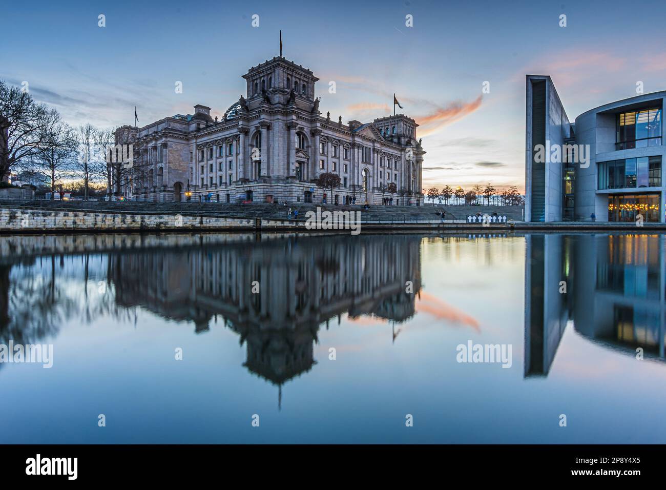 Sunset over the government district in Berlin.Reichstag in the capital of Germany in the evening. River Spree in front of the building with reflection Stock Photo