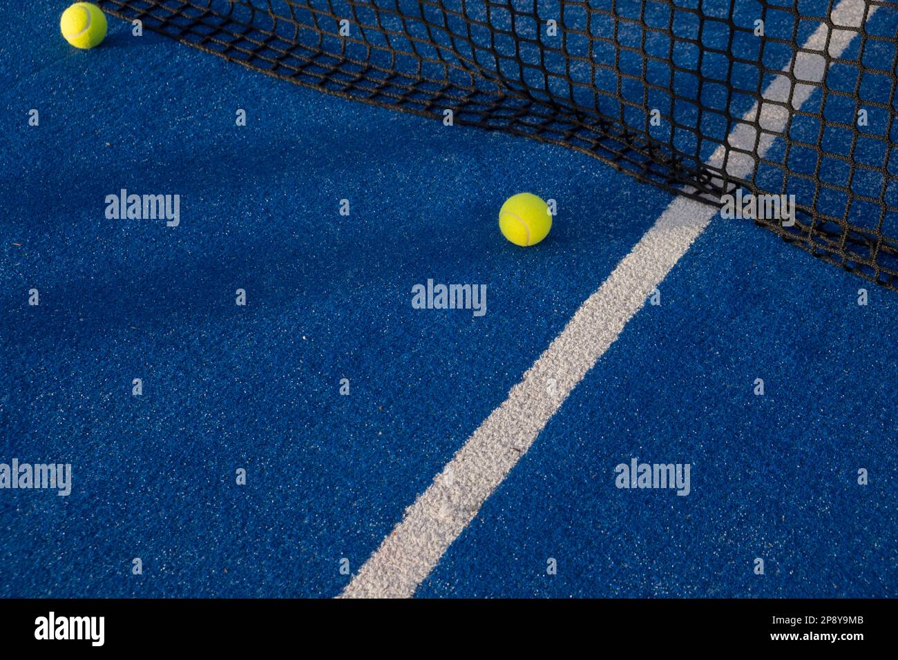 Paddle tennis ball near the net of a blue court Stock Photo