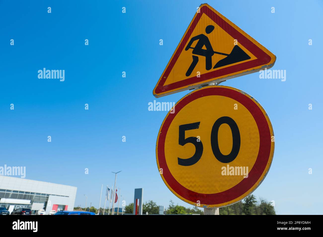 Speed Limit Building Road construction and speed limit signs outdoors on sunny day. Repair ...