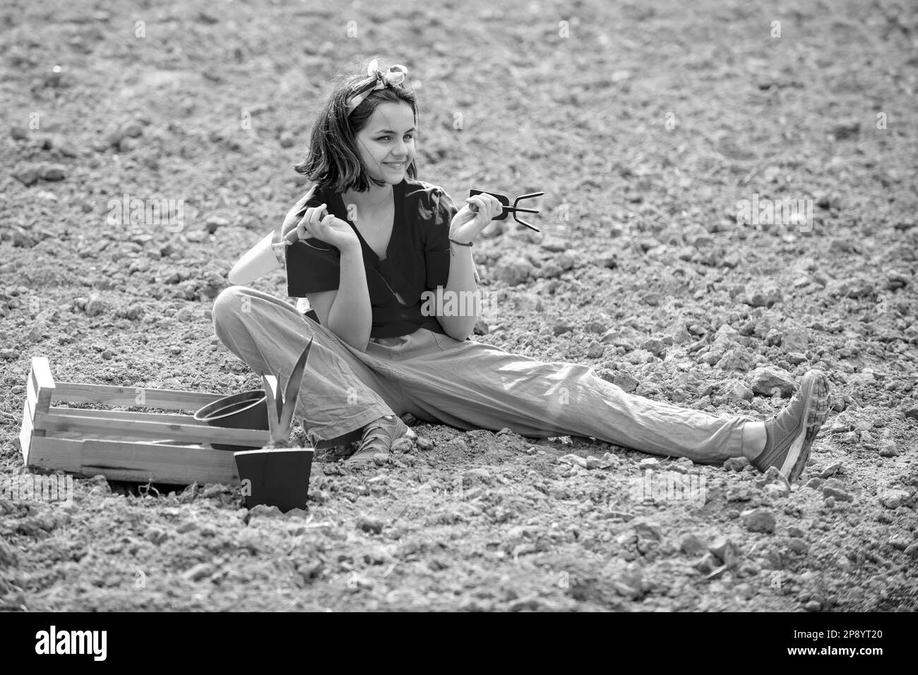 Child girl having fun with little shovel and plant in pot. Child care plants. Little helper in garden. Eco life. Planting seedlings. Stock Photo