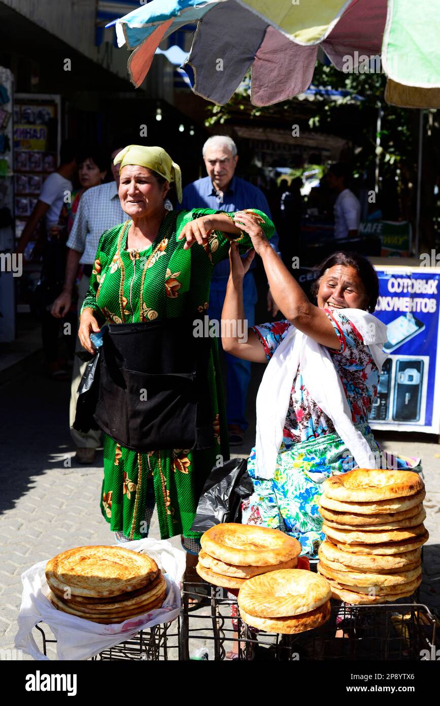 An Uzbek woman selling Obi Non- a traditional Uzbek / Tajik bread sold at the market in Bukhara, Uzbekistan. Stock Photo