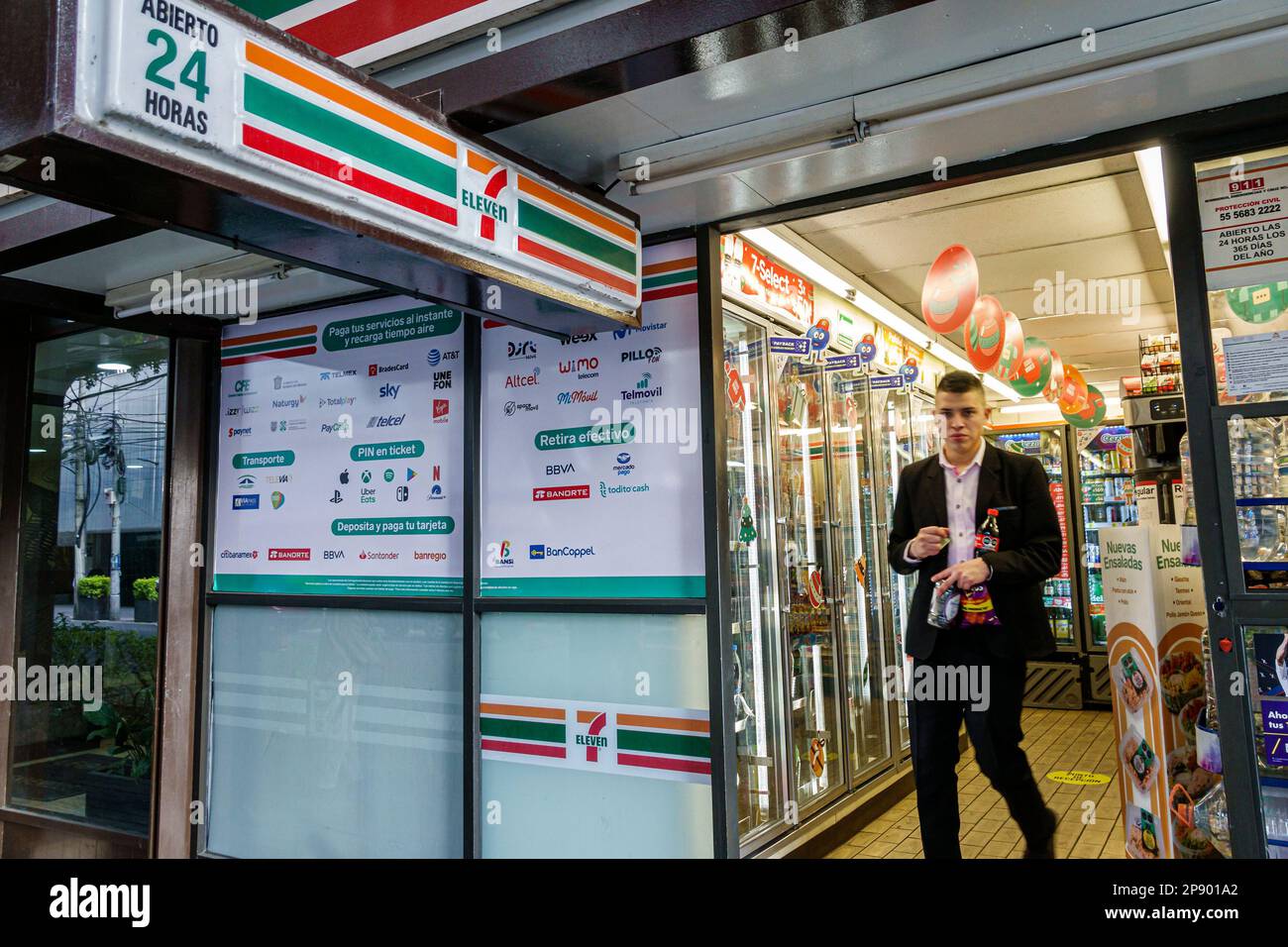 Mexico City,7-Eleven leaving exiting,man men male,adult adults,resident residents,outside exterior,building buildings,front entrance,convenience food Stock Photo