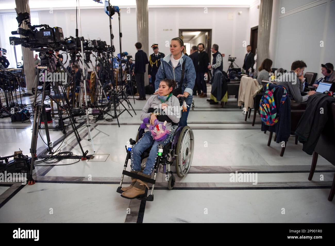 A mother and her daughter with disability leave the protest after 4 days due to deteriorating health. It is the 4th day since a group of Persons with disabilities along with their parents and care takers gathered in the Sejm (lower house of Parliament) on Monday 6th of March, demanding that the social pension be equalized with the national minimum. Among the protesters in the Sejm is also MP - Iwona Hartwich with her disabled son, Jakub. The PO's (Civic Platform) MP informed during a press conference that people with disabilities are submitting a draft act on social pension, after which almost Stock Photo