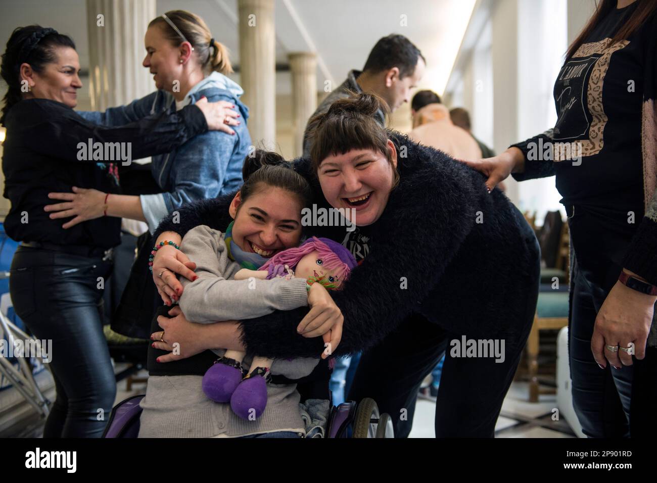 Two girls with disabilities hug each other tenderly goodbye, as one of them is about to leave the protest due to declining health. It is the 4th day since a group of Persons with disabilities along with their parents and care takers gathered in the Sejm (lower house of Parliament) on Monday 6th of March, demanding that the social pension be equalized with the national minimum. Among the protesters in the Sejm is also MP - Iwona Hartwich with her disabled son, Jakub. The PO's (Civic Platform) MP informed during a press conference that people with disabilities are submitting a draft act on socia Stock Photo