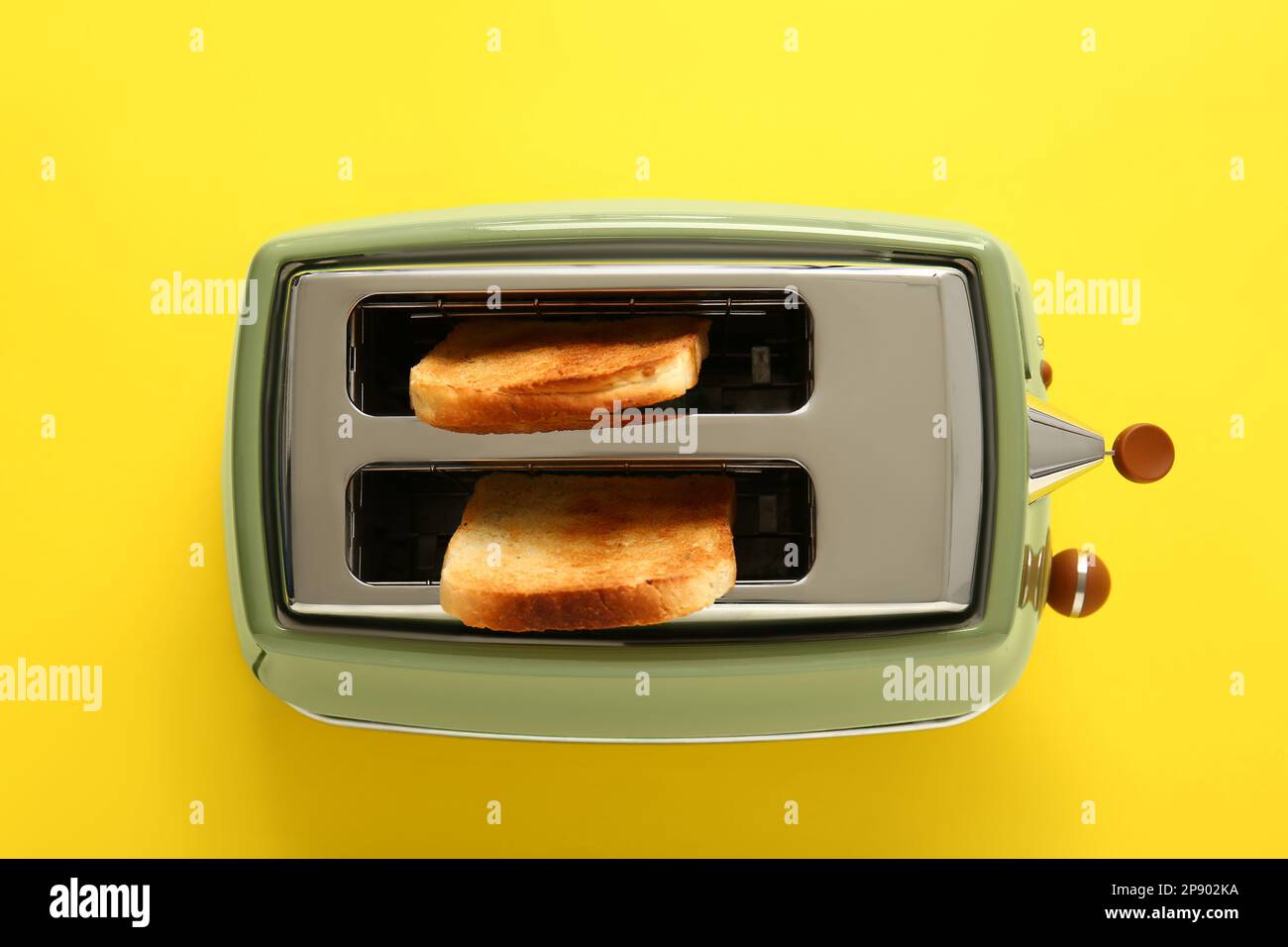 Modern toaster with crispy bread slices on yellow background Stock ...