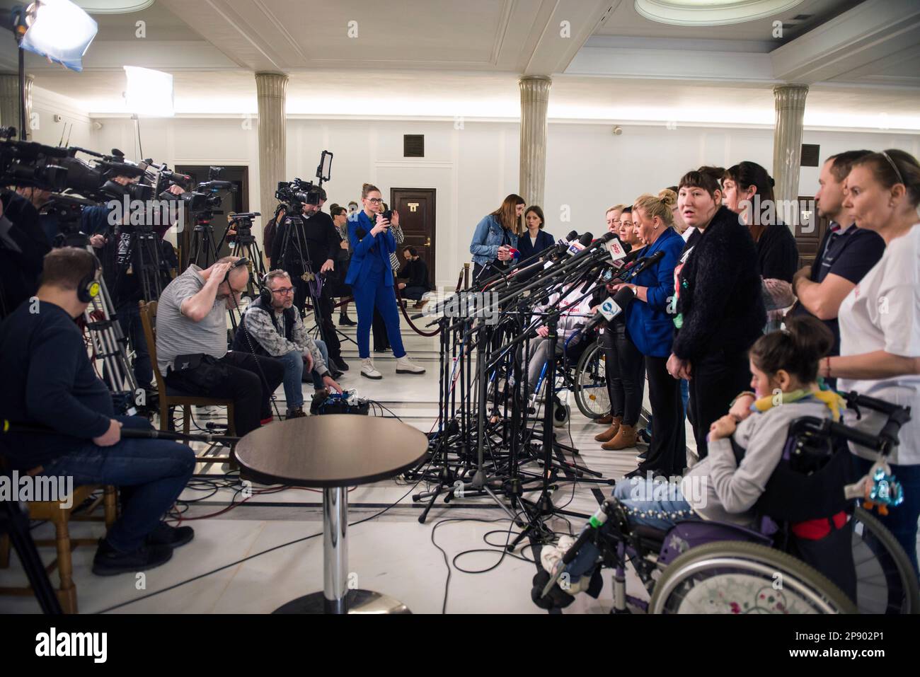 Protesting persons with disabilities along with their parents and care takers are seen during a press conference in the Parliament. It is the 4th day since a group of Persons with disabilities along with their parents and care takers gathered in the Sejm (lower house of Parliament) on Monday 6th of March, demanding that the social pension be equalized with the national minimum. Among the protesters in the Sejm is also MP - Iwona Hartwich with her disabled son, Jakub. The PO's (Civic Platform) MP informed during a press conference that people with disabilities are submitting a draft act on soci Stock Photo