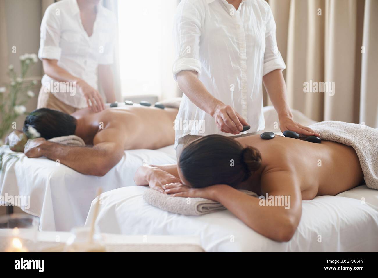 Getting good circulation going with some hot stone massage. a mature couple  enjoying a hot stone treatment Stock Photo - Alamy