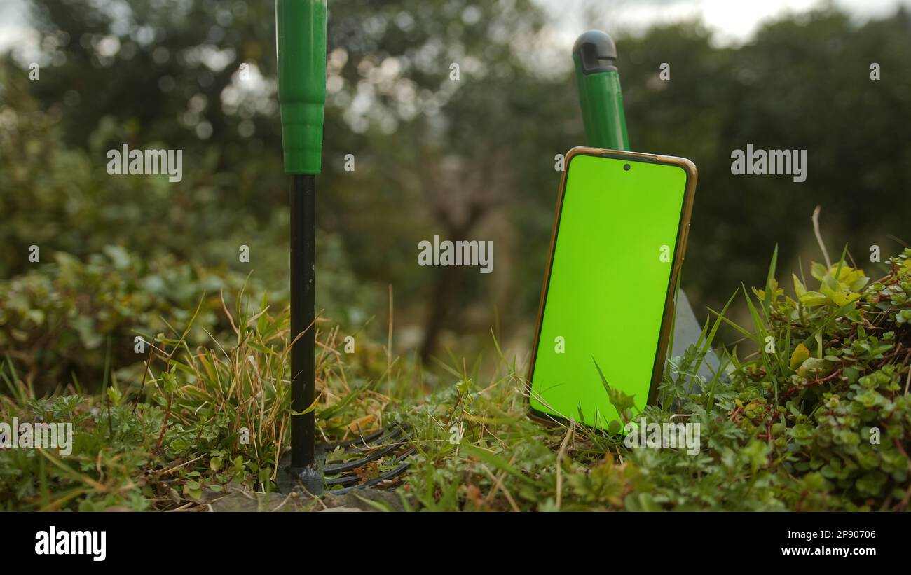 Revolutionizing Farming: Smart Using App on Green Screen Smartphone, Tending to the Earth Stock Photo