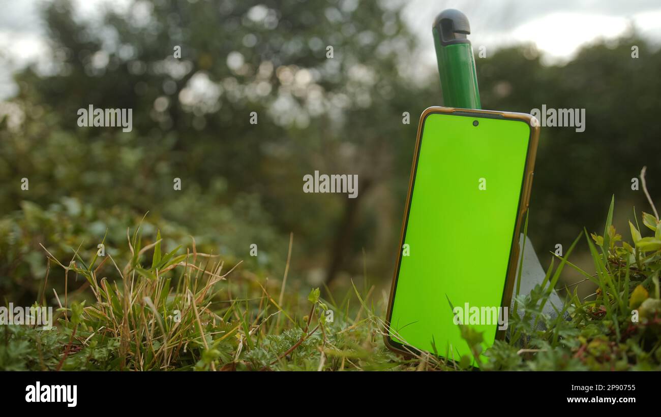 Using Farming App on Smartphone, Surrounded by Lush Greenery Stock