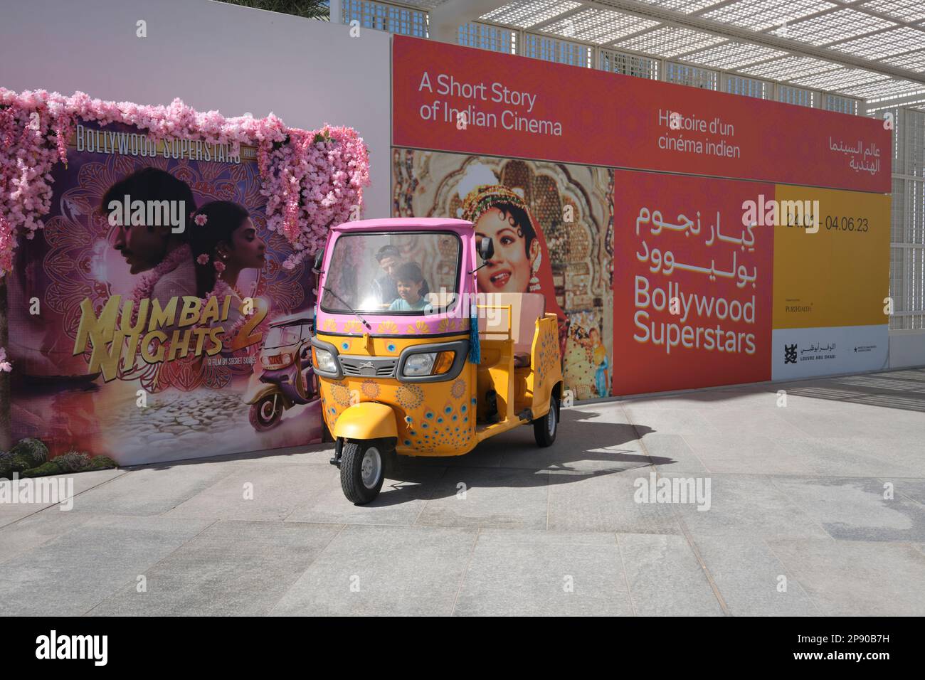 A cute yellow and pink auto-rickshaw, tuk tuk, part of a temporary show ...