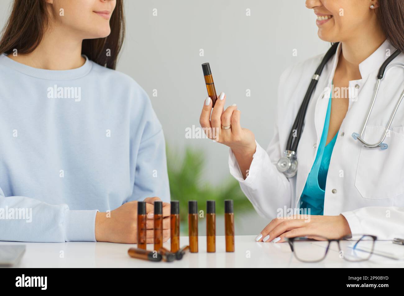 Doctor giving herbal essential oil flask inhaler female patient Stock Photo