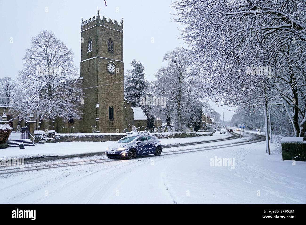 A car drives through the heavy snowfall in Lanchester, County Durham