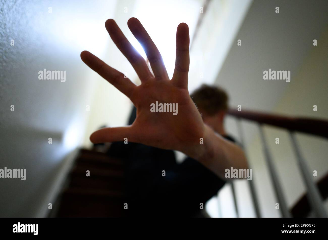 Hamburg, Germany. 12th Feb, 2023. A man sits in the stairwell and makes