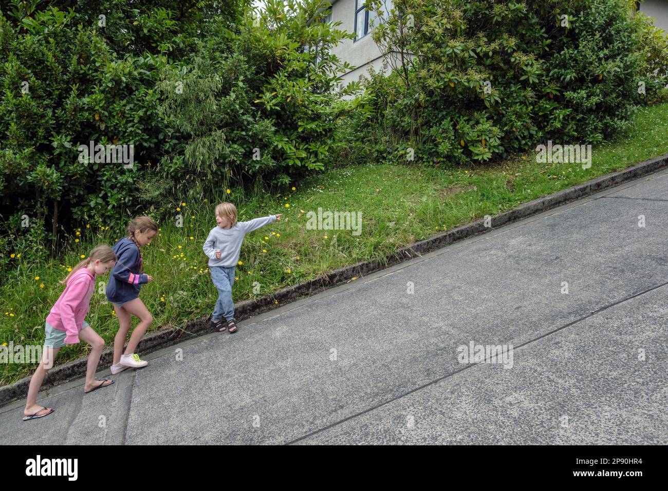 Children walking up the steepest street in the world - Baldwin Street, Dunedin, South Island, New Zealand Stock Photo