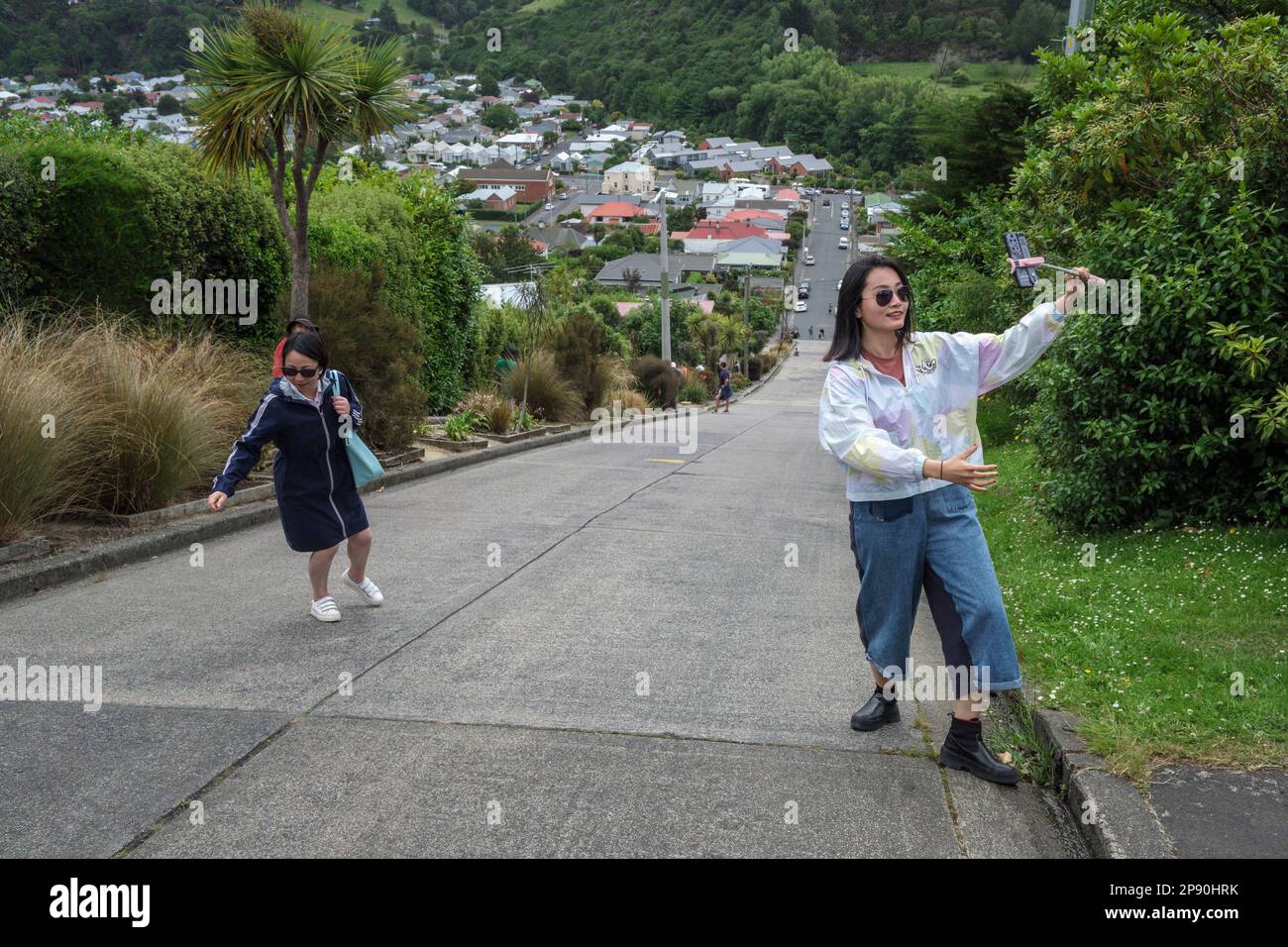 Tourists taking photographs on the steepest street in the world - Baldwin Street, Dunedin, South Island, New Zealand, 2022 Stock Photo