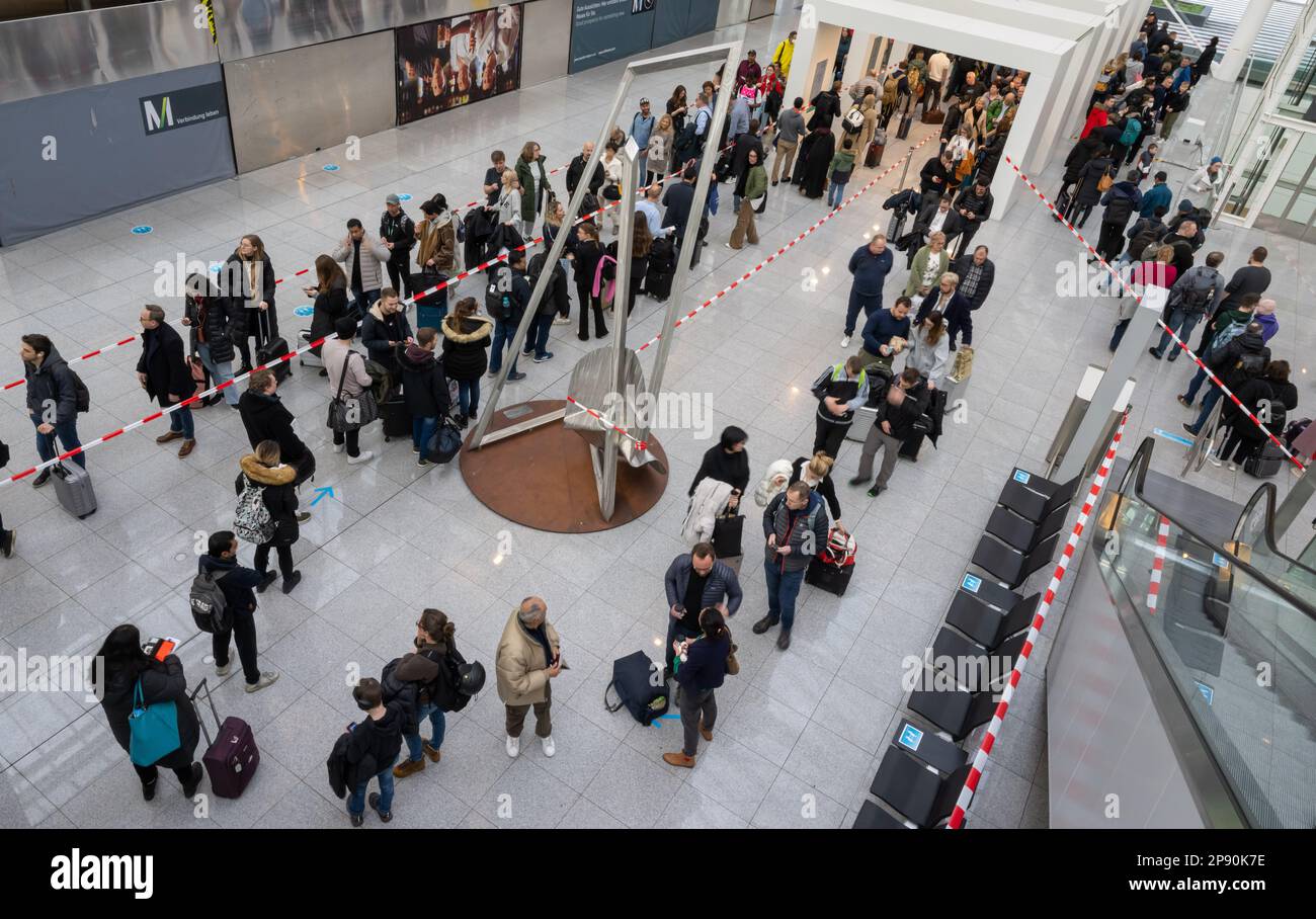 10 March 2023, Bavaria, MünchenFlughafen Passengers queue in the departure hall to get to the