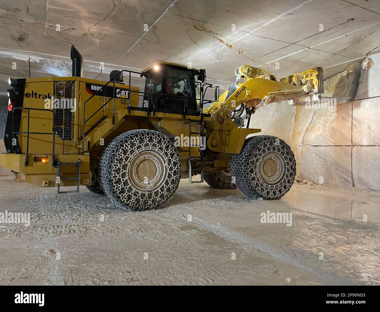 Wheel loaders working on huge underground marble quarry, exploitation of marbles. Stock Photo