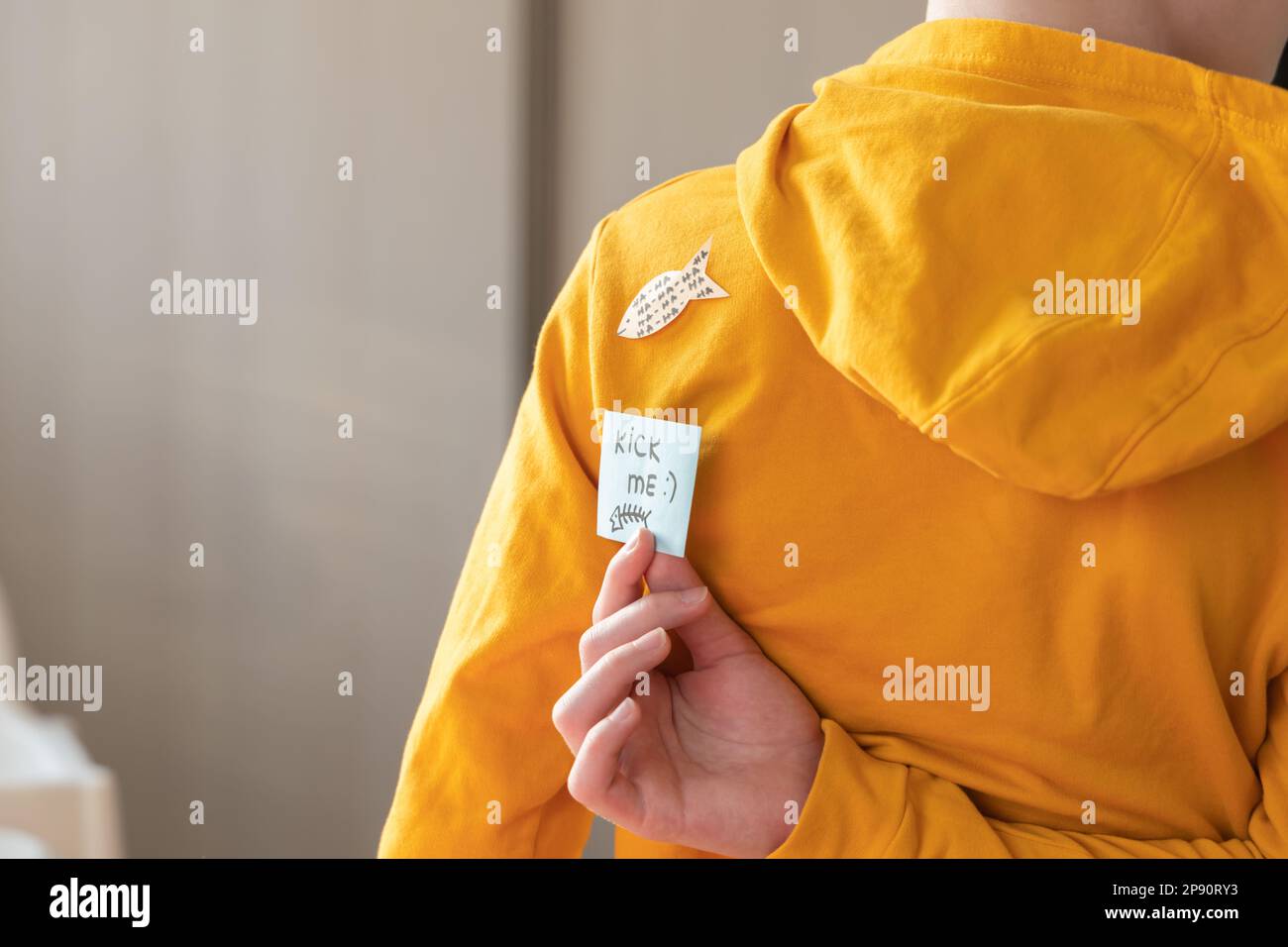 April 1st Fools' day.Young boy with sticker. Sticker on back say kick