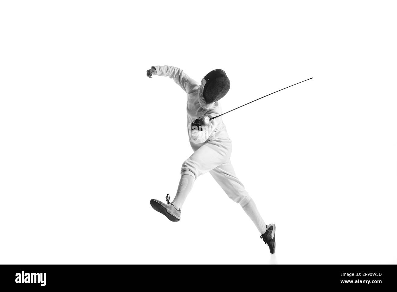 Professional male fencer in fencing costume training with sword isolated on white studio background. Concept of sport, competition, professional Stock Photo