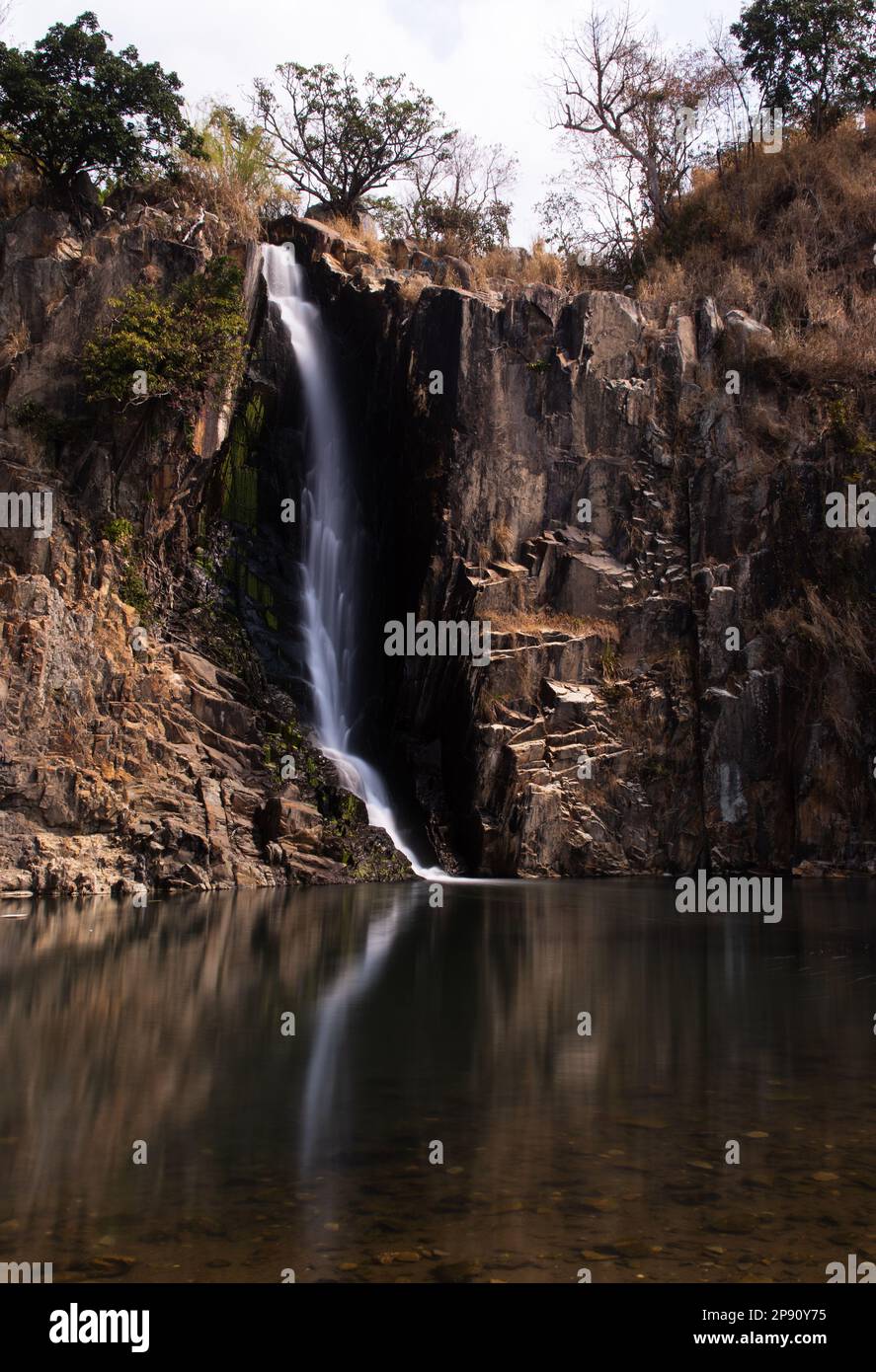 This waterfall cascades down to a large pool on a beach in Hong Kong between resedential buildings. Stock Photo