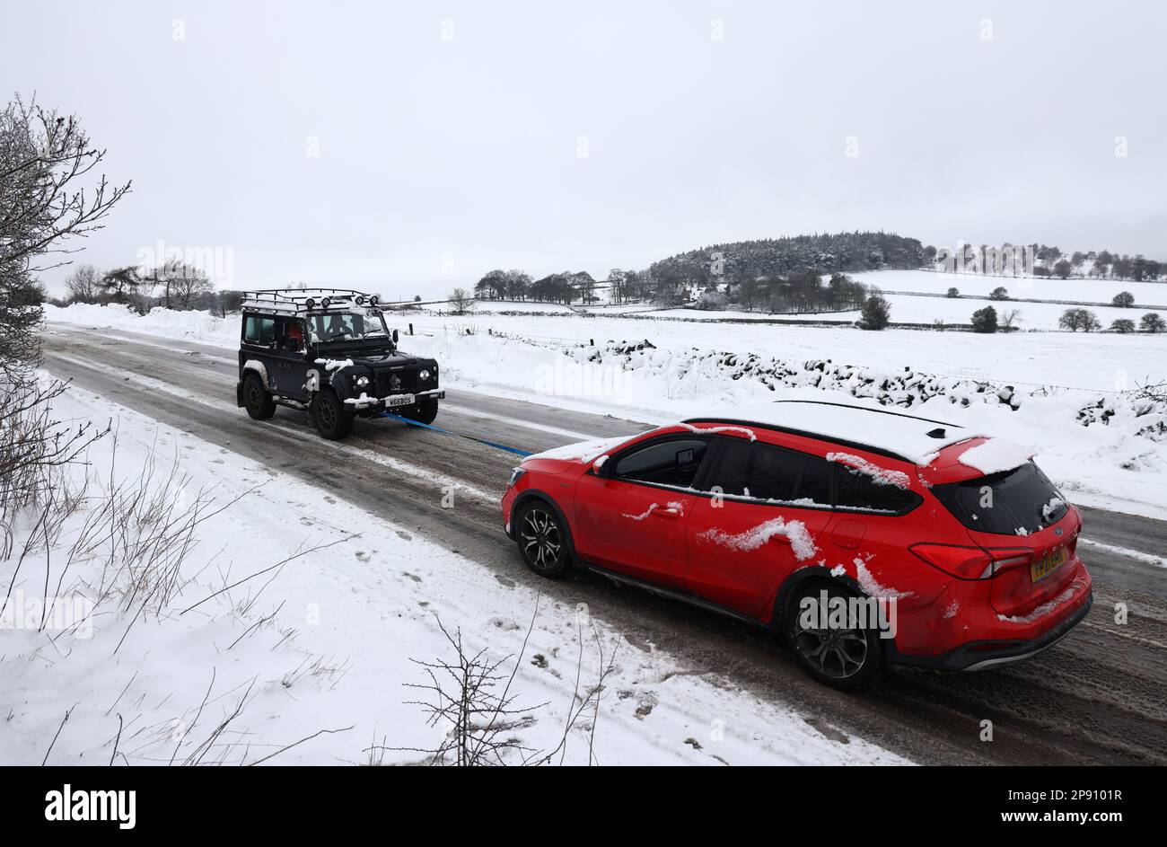 Coalville, Leicestershire, UK. 10th March 2023. UK weather. A Land Rover driver tows a car up a snow and ice covered hill. Freezing conditions and strong winds across much of the UK are affecting roads and railways, with hundreds of schools closed. Credit Darren Staples/Alamy Live News. Stock Photo