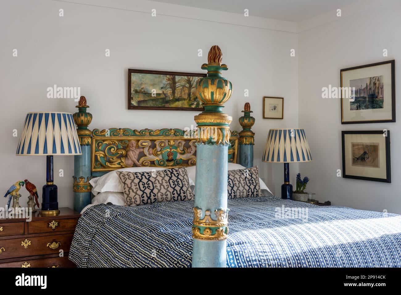 Carved Indian bed from Kerala with artwork and antique Welsh dresser in