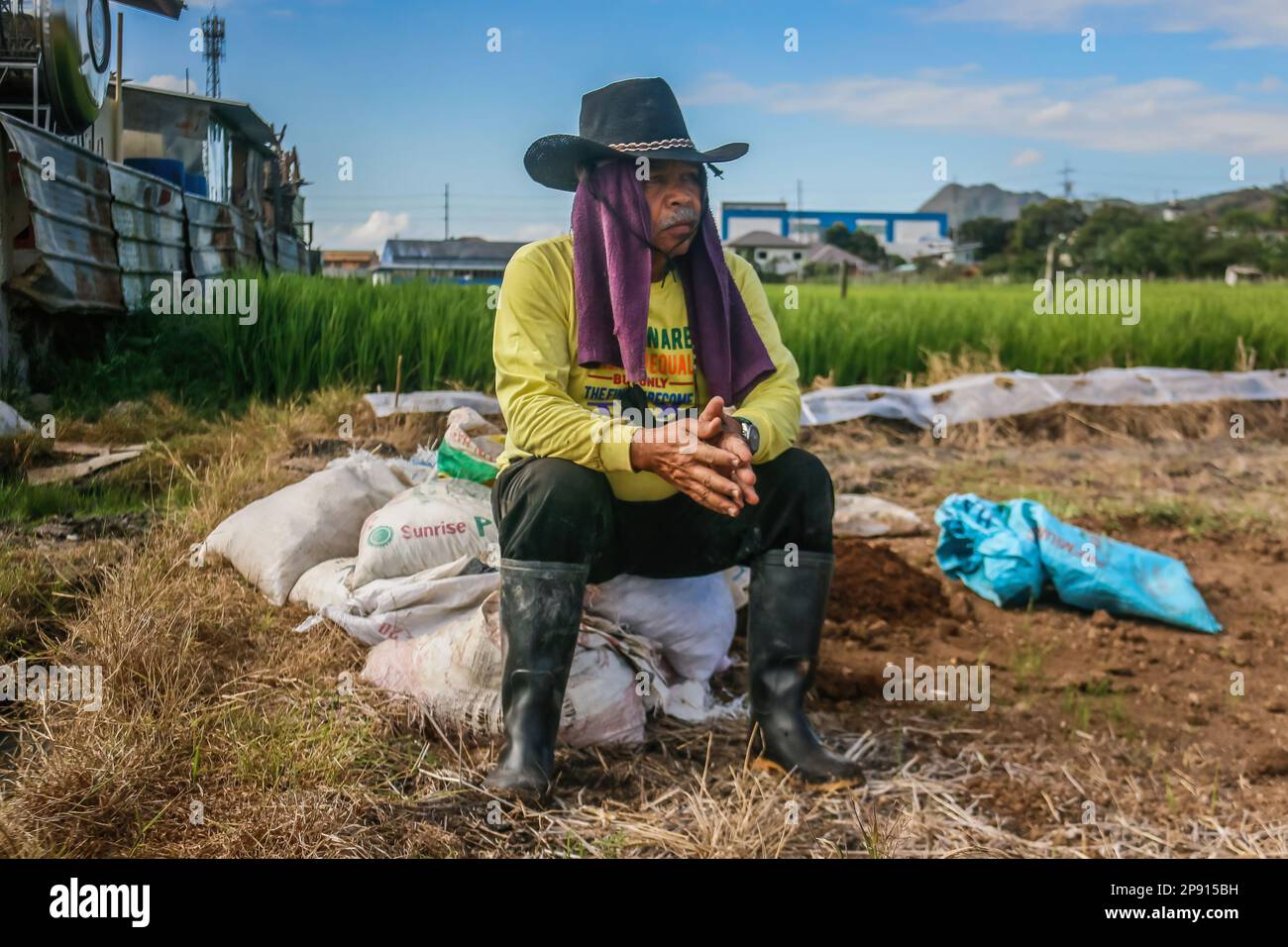 A Farmer Sits On Sacks Of Manure On A Small Agricultural Land In Teresa a-farmer-sits-on-sacks-of-manure-on-a-small-agricultural-land-in-teresa