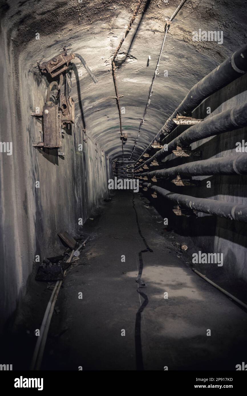 abandoned and decaying tunnel with piping Stock Photo