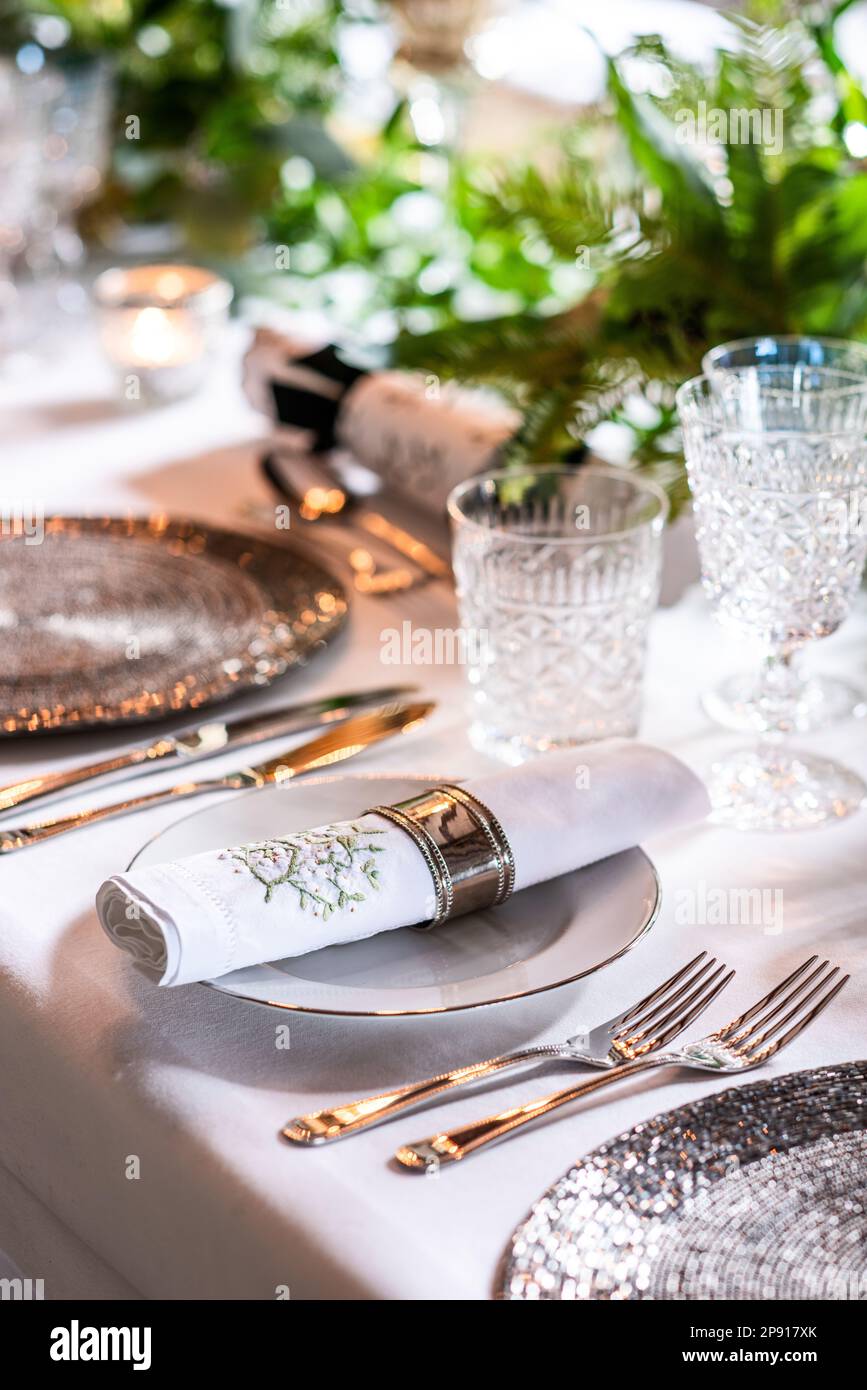Embroidered napkin and crystal glasses at place setting in country house, Kent, UK Stock Photo
