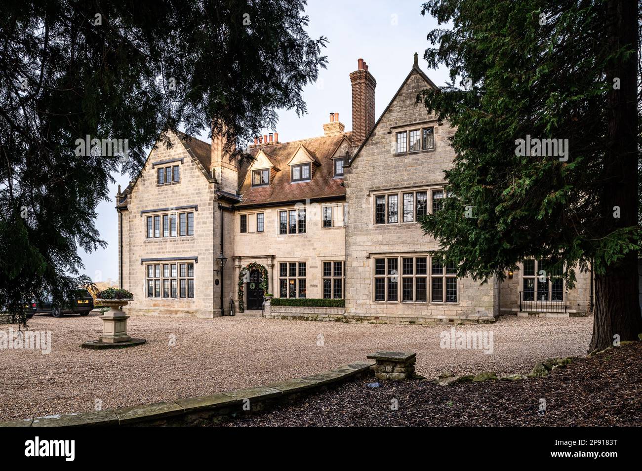 Gravel driveway and exterior of Arts and Crafts style country house