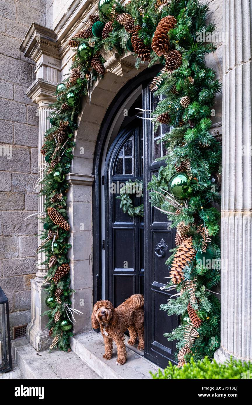 Festive decorations on arched doorway of Arts and Crafts style country