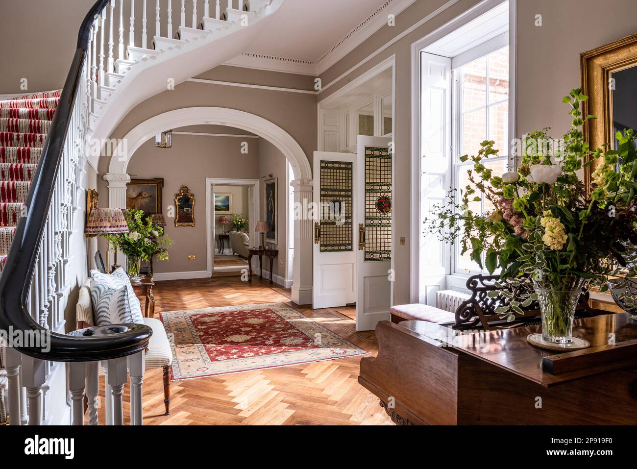 Staircase with grand piano in renovated entrance of 18th century Grade II listed Suffolk country house, UK Stock Photo