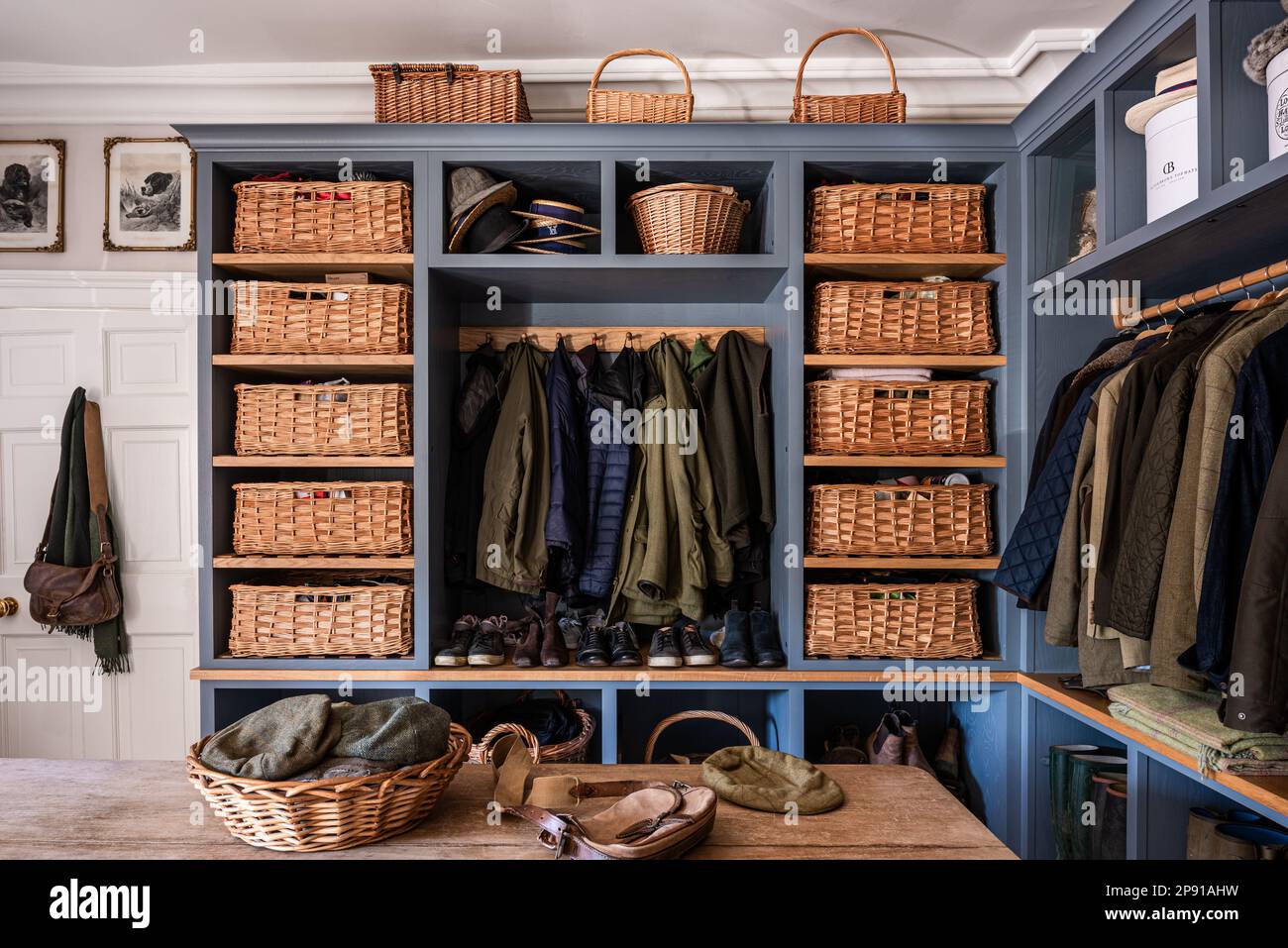 Bootroom with baskets and coats in 18th century Grade II listed Suffolk country house, UK Stock Photo