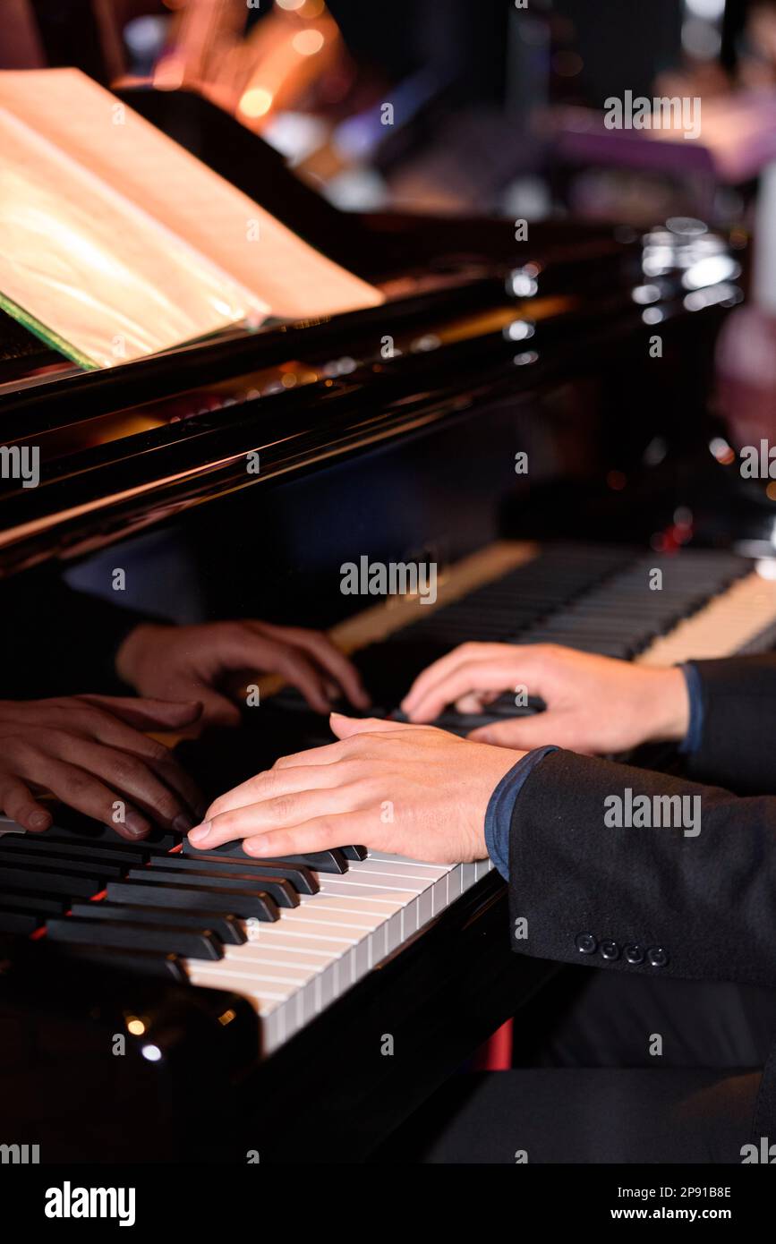 Male piano player. Hands and piano keys close up. Stock Photo
