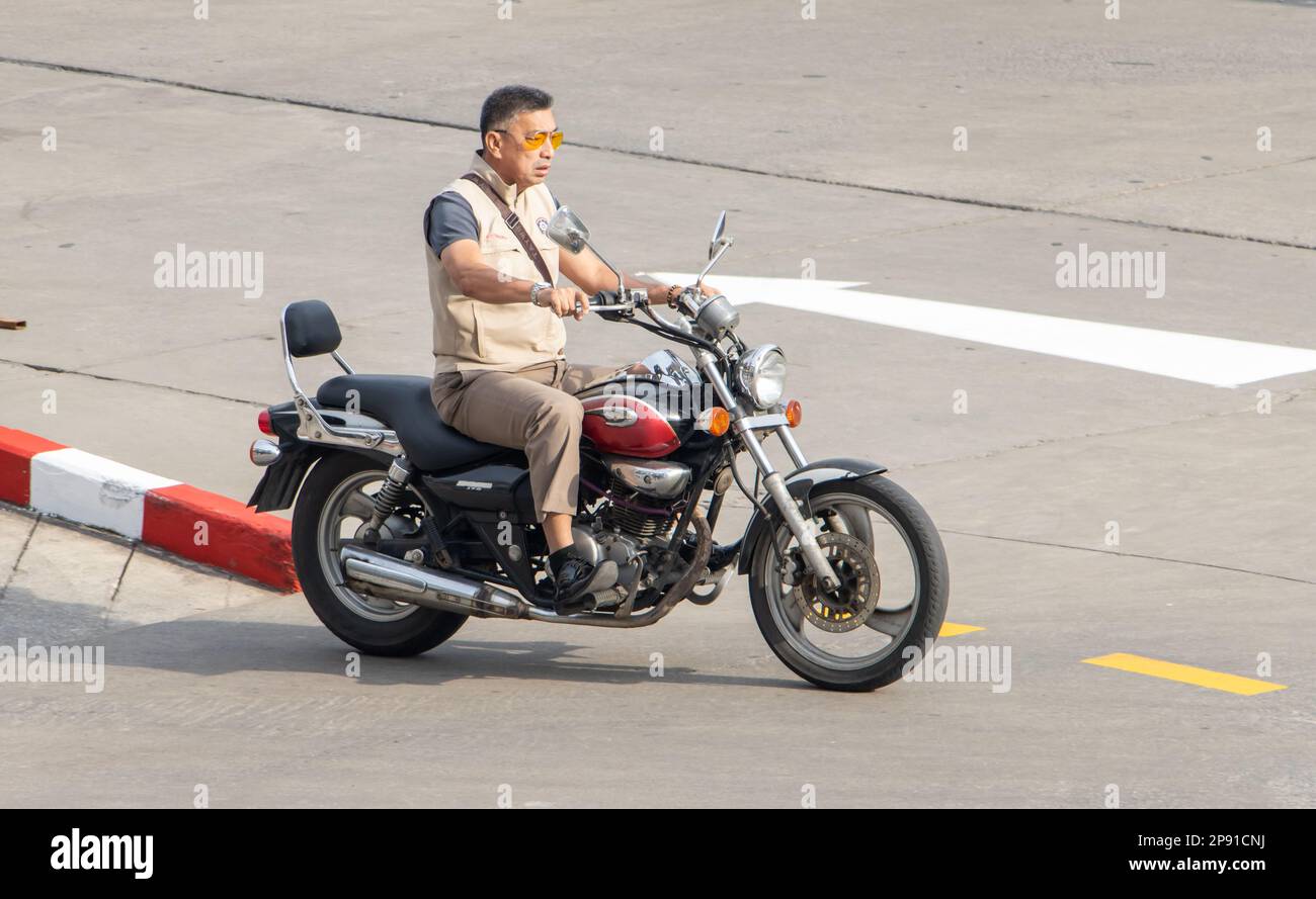 SAMUT PRAKAN, THAILAND, JAN 30 2023, A man rides a motorcycle at city street Stock Photo