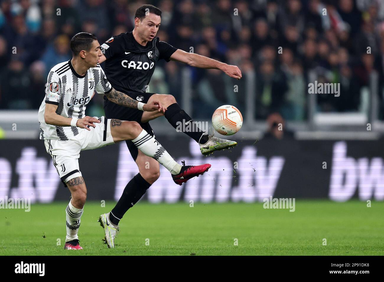 Angel Di Maria of Juventus Fc (L) and Nicolas Hofler of Sc Freiburg (R)  battle for the ball during the UEFA Europa League round of 16 first leg match beetween Juventus Fc and Sc Freiburg at Allianz Stadium on March 9 2023 in Turin, Italy . Stock Photo
