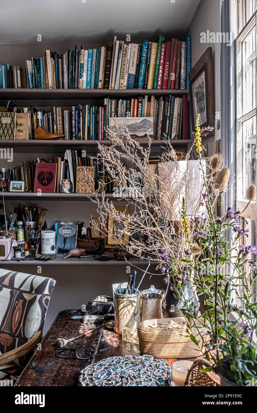 Bookshelves and dried flowers in artist's studio, Herne Bay, Kent, UK Stock Photo
