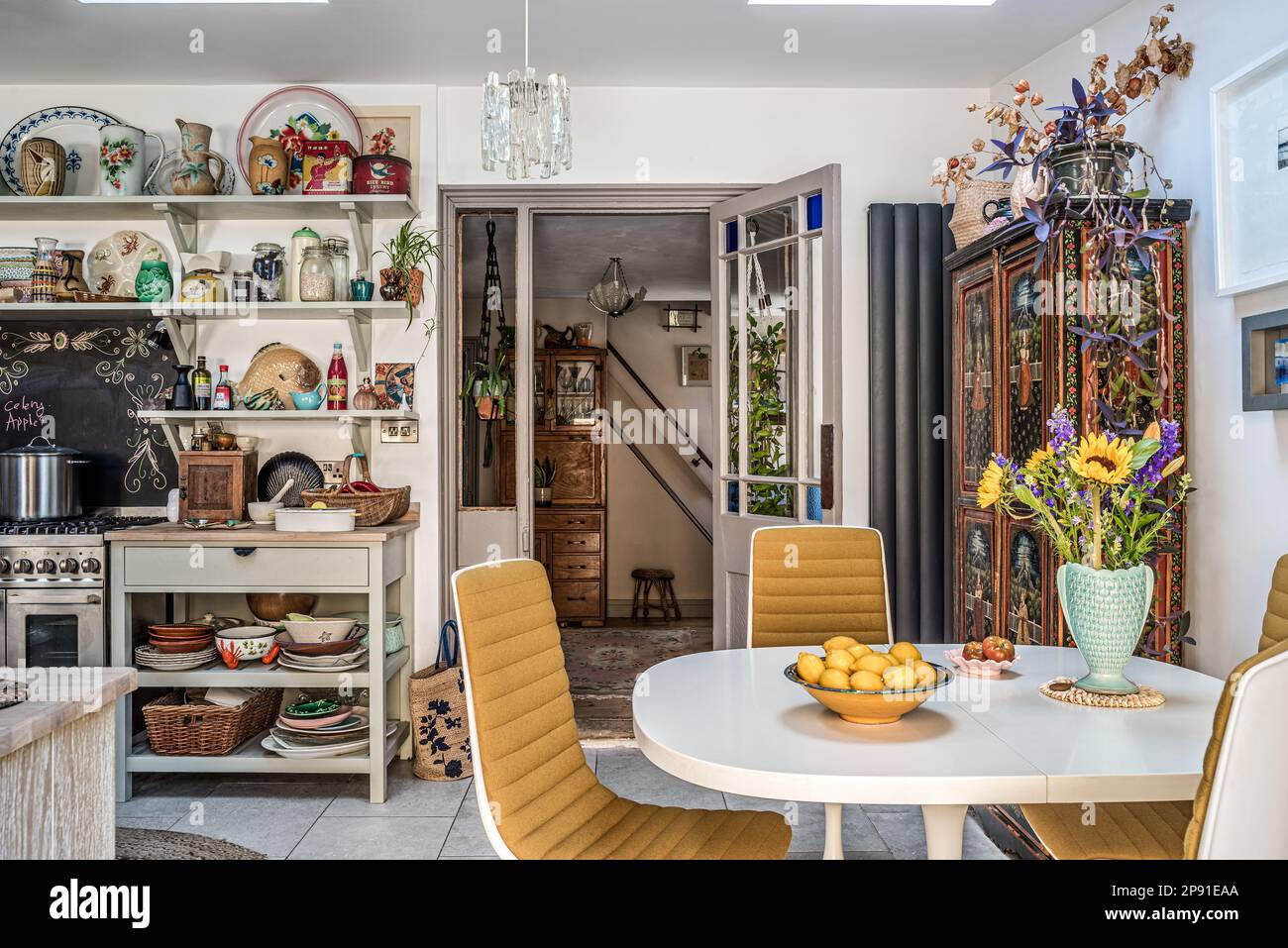 Vintage plates and vase display with 1970s table and chairs and Indian cupboard in updated 19th century coastal home, Herne Bay, Kent, UK. Stock Photo