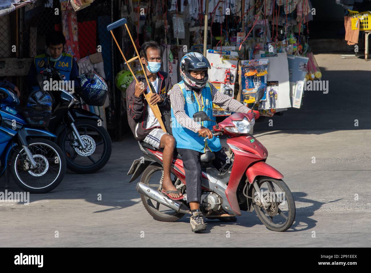 SAMUT PRAKAN, THAILAND, FEB 13 2023, A man with crutches rides with a moto taxi Stock Photo