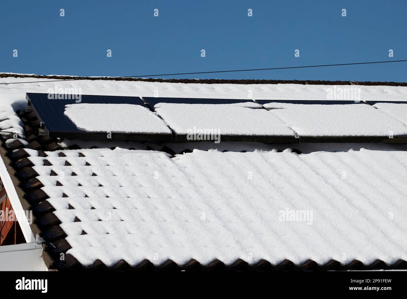 snow melting on solar panels on a house after heavy snowfall in winter