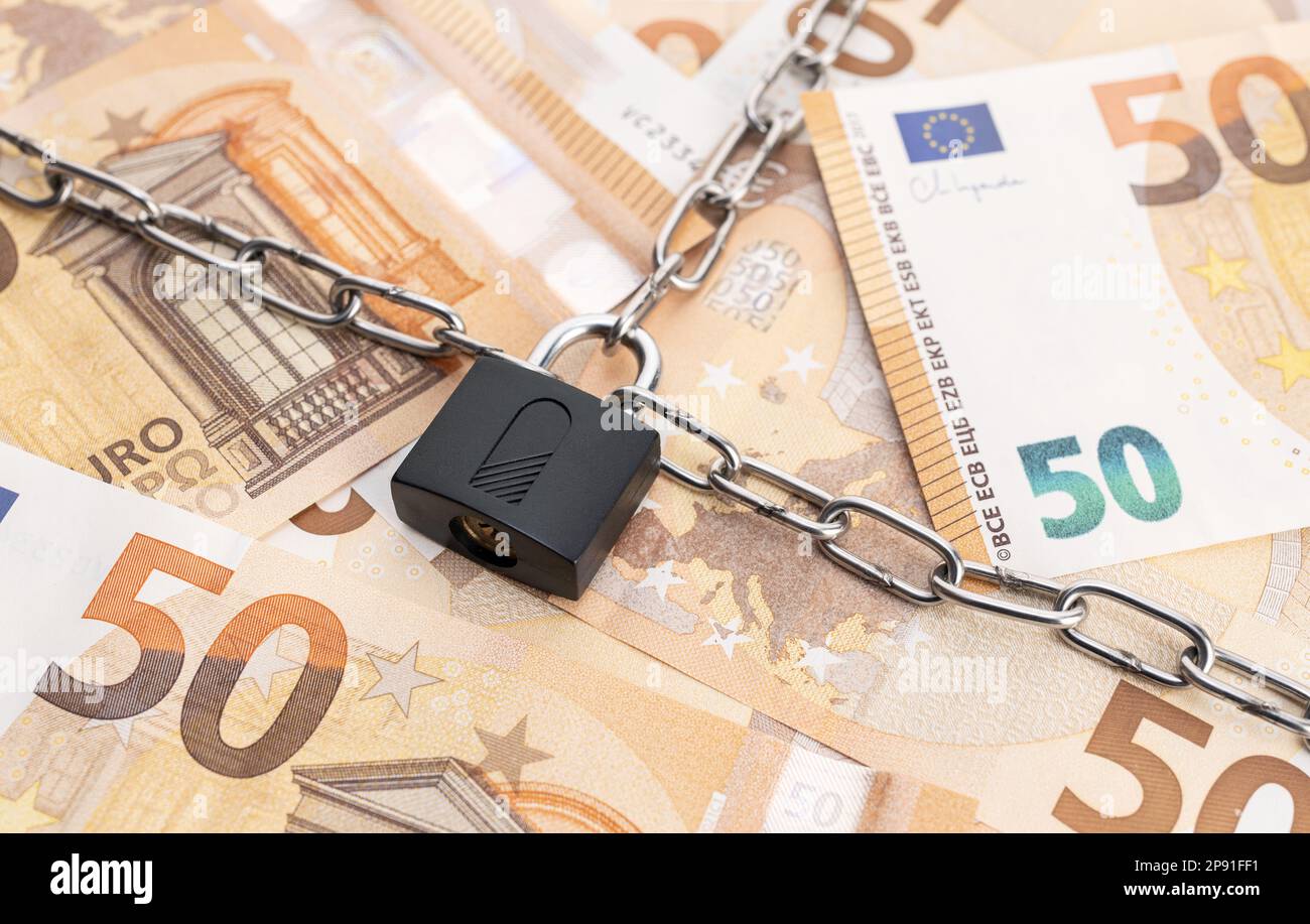 Lock security and chain on euro banknotes background. Monetary crisis, financial problems, sanctions, default concept Stock Photo