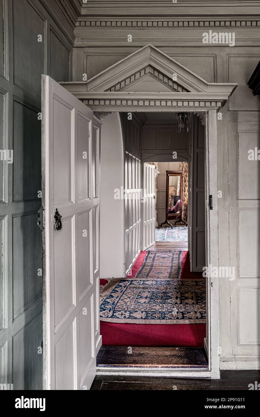 View through panelled doorway across hall to alternative bedroom in Wiveton Hall 17th century Jacobean manor house, Norfolk, UK Stock Photo