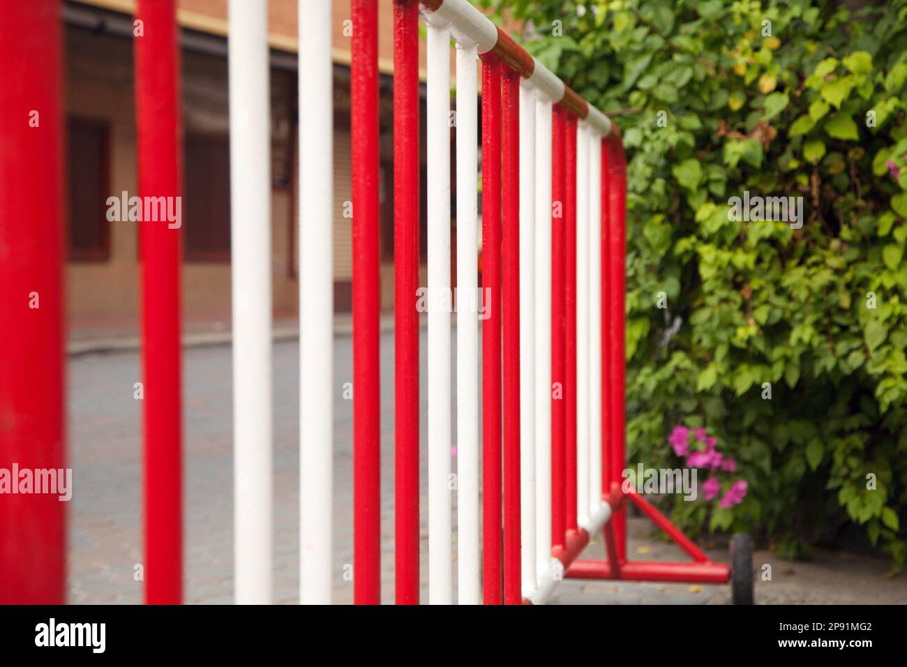 Metal red and white safety barrier on a road. Stop sign railing against