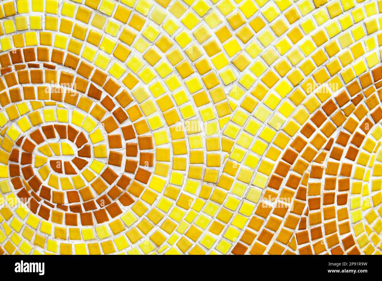 Yellow swirl pattern tiled bathroom wall. Mini square orange tiles background Stock Photo